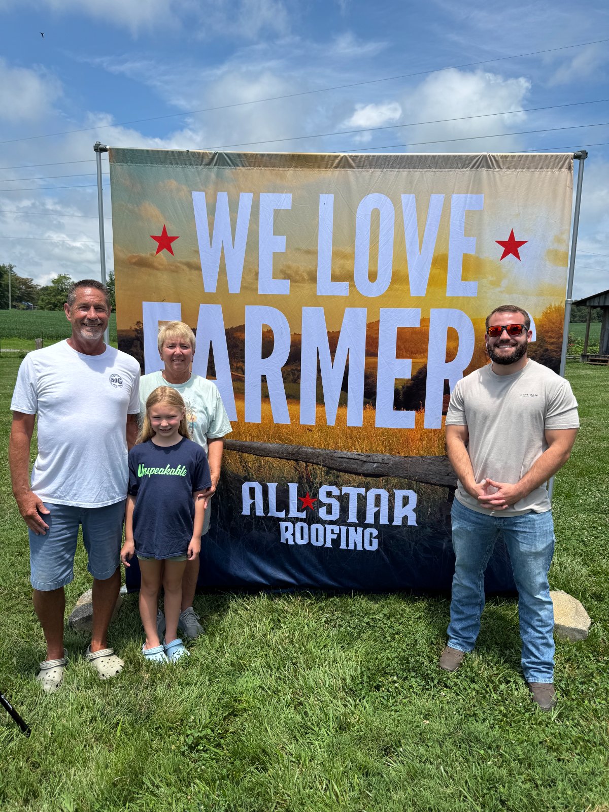 Customers with the We Love Farmers banner on their farm